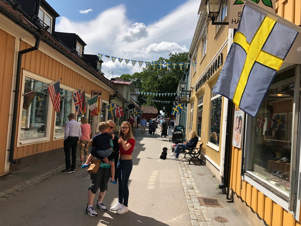 Sigtuna Main Street, cute wooden houses wooden houses Swedish flag Sigtuna city Tour from Stockholm