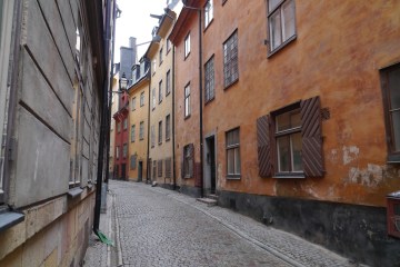 a narrow street in front of a brick building