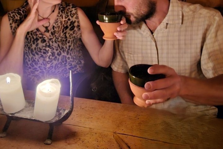 a person holding a glass of beer on a table