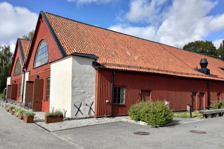 a large brick building with grass in front of a house