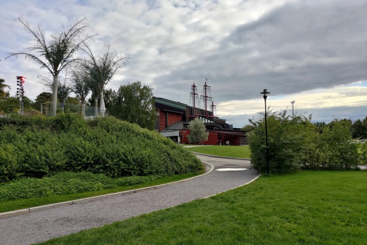 a large green field with trees in the background