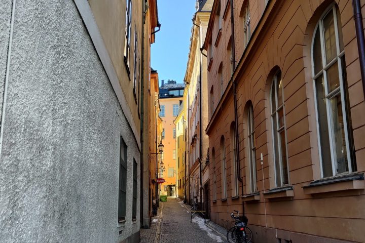 a person walking down a sidewalk in front of a brick building