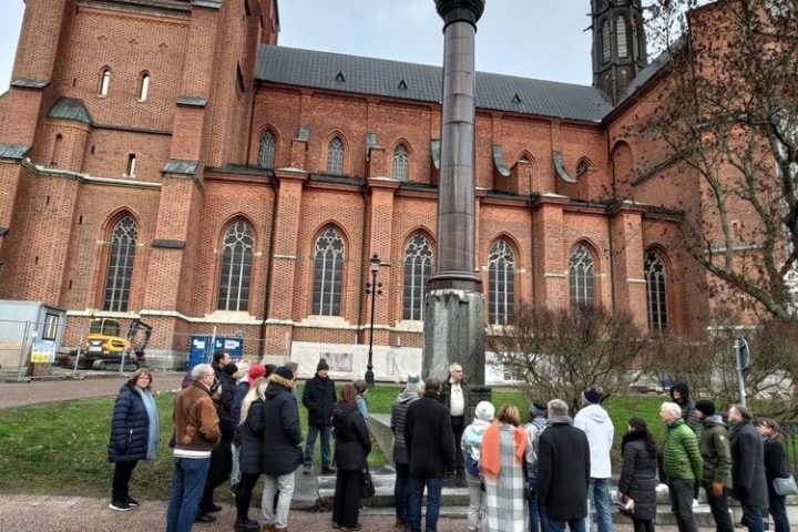 a group of people standing in front of a stone building