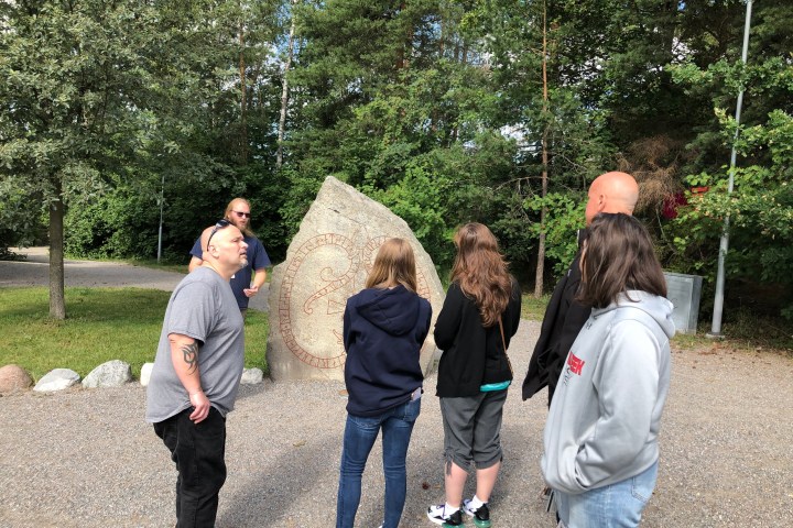 a group of people standing next to a tree