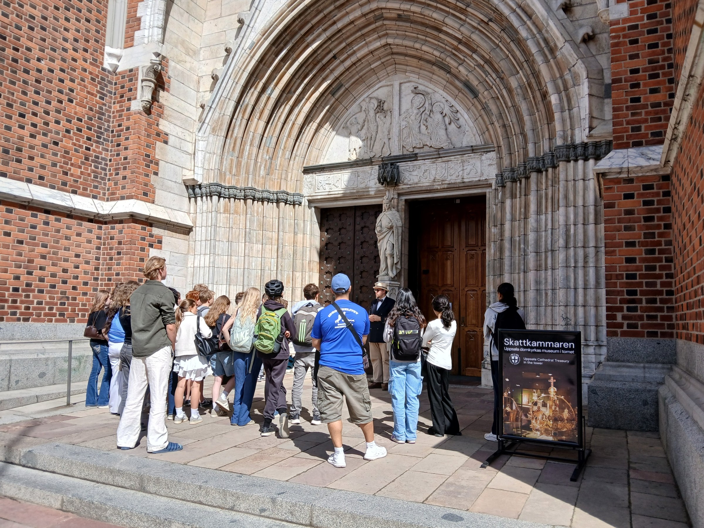 a group of people standing in front of a stone building