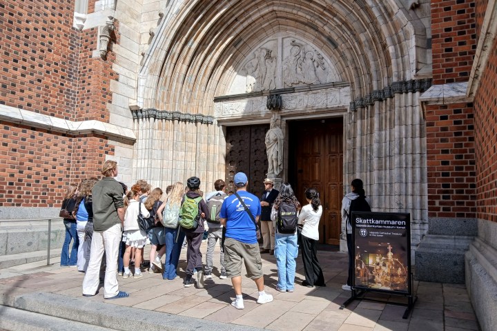 a group of people standing in front of a stone building
