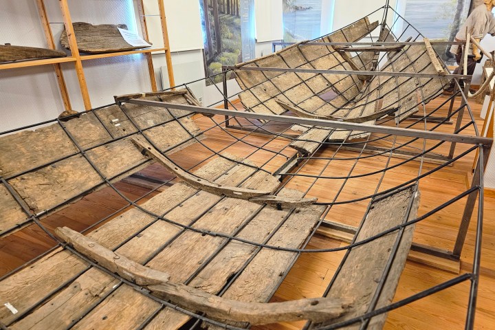 Exhibit of wooden boat frames displayed in a museum setting.